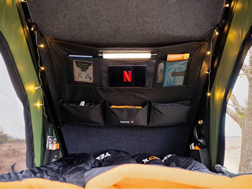 Inside view of the Cargo 2.0 tent showing two sleeping bags, a small screen setup, and overhead storage.

