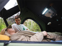 Couple lounging inside the Cargo 2.0, smiling while reading a book.

