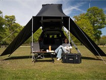 Woman lounging under the Cargo 2.0 Tunnel Awning shelter