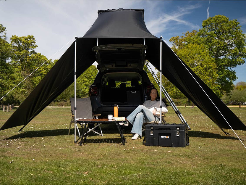Woman lounging under the Cargo 2.0 Tunnel Awning shelter