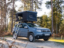 SUV with a TentBox Classic rooftop tent parked in a forest