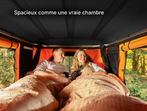   two people laying down inside a TentBox Classic roof top tent, showing off the size and space