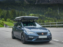 TentBox Classic closed in travel mode on a car driving along a mountain road