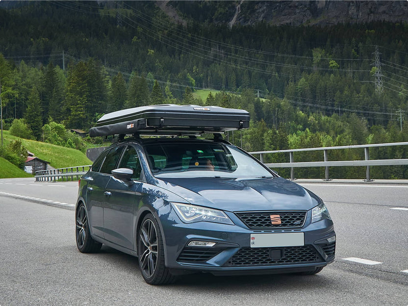 TentBox Classic closed in travel mode on a car driving along a mountain road