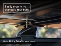 Close-up of TentBox Classic's mounting system, showing bolts securely attached to standard roof bars. Text overlay reads “Easily mounts to standard roof bars” with a callout to the “Fitting Guide.”