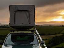 Front view of TentBox GO against a sunset backdrop