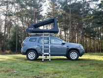 Side view of the TentBox GO installed on a Dacia Duster in the forest