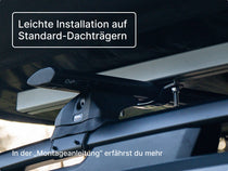 Nahaufnahme des GO Dachzelts, montiert auf Standard-Dachträgern, mit sichtbaren Schrauben und Halterungen; enthält einen Hinweis zum „Montage-Guide“.