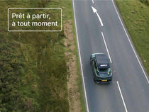 Vue aérienne d’une voiture roulant avec la tente GO fixée sur le toit, illustrant son profil mince en transit.