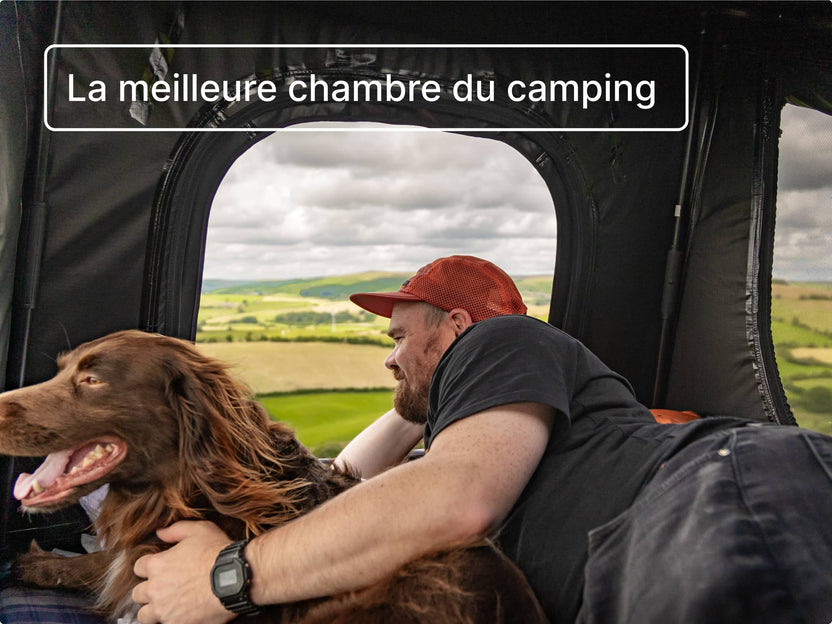 Un homme et son chien regardant dehors depuis l’intérieur de la tente GO, porte ouverte ; une ambiance chaleureuse et joyeuse.