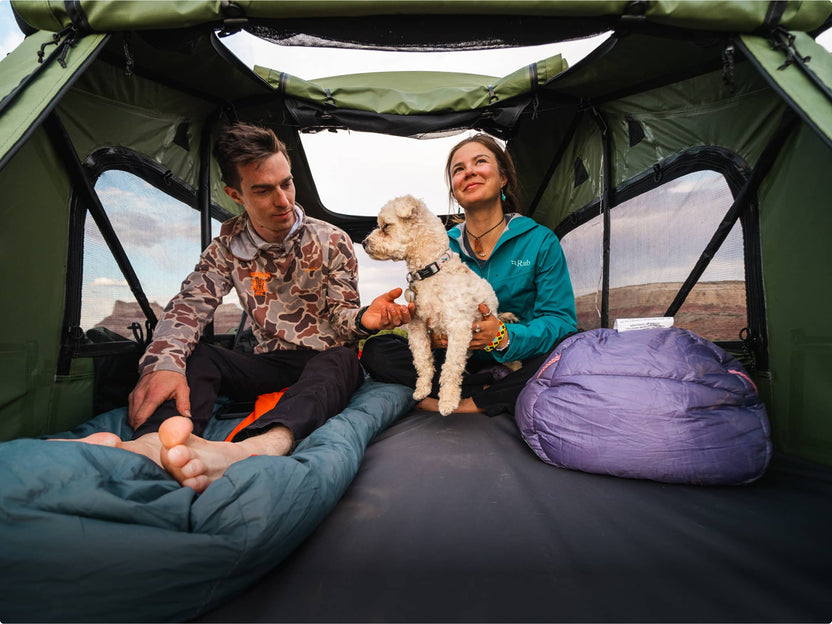 Couple and dog relaxing inside a TentBox, enjoying the view from inside