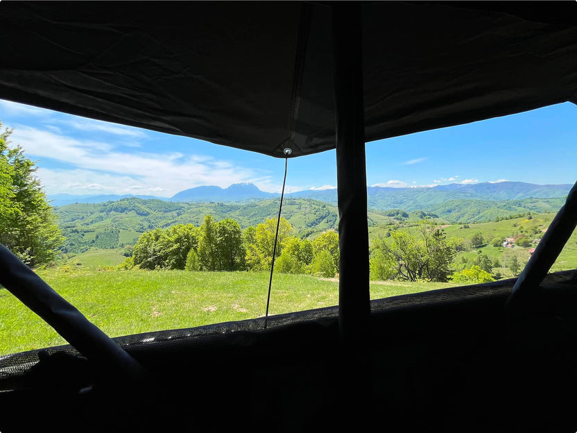 Landscape view from inside a TentBox showing a lush valley under clear skies