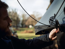 Person installing porch poles on Lite 2.0 roof tent