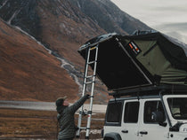 Opening the TentBox Lite XL in the Forest Green colour, with the Scottish mountains in the background.