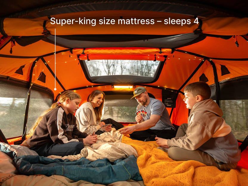  People in TentBox Lite XL playing cards showing it has a super-king mattress and sleeps 4