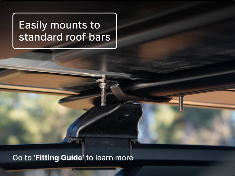 Close-up view of a TentBox mounting system showing bolts and brackets attaching it securely to standard roof bars. Text overlay says “Easily mounts to standard roof bars” with a note directing users to the “Fitting Guide.”